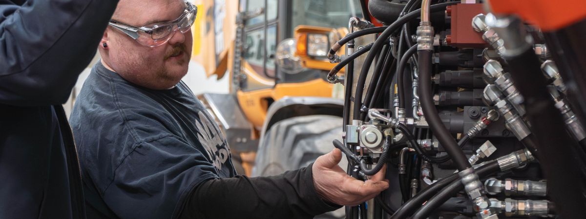 A person working on mechanical heavy equipment